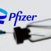 A syringe and vial are seen in front of a displayed Pfizer logo in this illustration taken June 24, 2021. REUTERS/Dado Ruvic/Illustration/File Photo